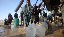 يتجمع الفلسطينيون النازحون لجلب الماء وسط خيام متداعية، ما يعكس تدهور الأوضاع المعيشية والنقص الحاد في الاحتياجات الأساسية، مخيم النصيرات للاجئين وسط قطاع غزة، 31 مارس/آذار 2026. تصوير: حسن الجديدي