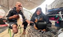 يعيش المواطن الفلسطيني محمود الزربا، الذي فقد بصره وبُترت ساقه اليمنى إثر إصابته في قصف إسرائيلي، مع أطفاله الستة في ظروف إنسانية صعبة داخل خيمة في دير البلح وسط قطاع غزة، 27 أبريل/نيسان 2026. (صورة: يوسف أبو وطفة)