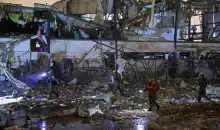 فرق الطوارئ تعاين الدمار بعد سقوط صاروخ باليستي إيراني في منطقة صناعية بمدينة بتاح تكفا (الفرنسية).webp