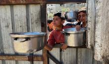 يتلقى فلسطينيون نازحون طعامًا من مطبخ خيري في مخيم النصيرات للاجئين وسط قطاع غزة، في 23 أبريل/نيسان 2026، (صورة: يوسف أبو وطفة)