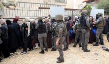 عائلات فلسطينية تنتظر عند نقطة تفتيش تابعة للجيش الإسرائيلي عند مدخل مخيم جنين للاجئين، قرب مدينة جنين في الضفة الغربية، لاستعادة ممتلكاتها من منازلها، 13 أبريل/نيسان 2026. صورة: محمد ناصر