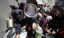 إحدى الجمعيات الخيرية توزع وجبات طعام على الفلسطينيين النازحين في مخيم النصيرات للاجئين، في ظل استمرار نقص الغذاء نتيجةً للسياسة الإسرائيلية المتعلقة بدخول المساعدات إلى مدينة غزة، في 11 أبريل/نيسان 2026. (تصوير: حسن جيدي)