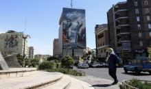 امرأة تمر أمام لوحة إعلانية كبيرة عن مضيق هرمز في طهران. (أ ف ب).jpeg