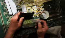 بائع فلسطيني يبيع سجائر مصنوعة من أوراق الملوخية المجففة كبديل للتبغ (رويترز).webp