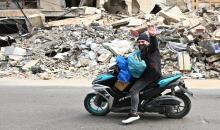 نازح لبناني عائدا إلى ركام المنازل ويظهر من خلفه آثار الدمار. (أ ف ب).jpeg