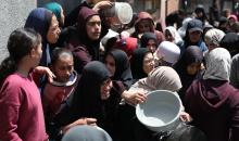 إحدى الجمعيات الخيرية توزع وجبات طعام على الفلسطينيين النازحين في مخيم النصيرات للاجئين، في ظل استمرار نقص الغذاء نتيجةً للسياسة الإسرائيلية المتعلقة بدخول المساعدات إلى مدينة غزة، في 11 أبريل/نيسان 2026. (تصوير: حسن جيدي)