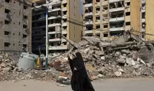 لبنانية توثّق الدمار بالضاحية الجنوبية لبيروت خلال جولة للصحافيين نظّمها «حزب الله» الأربعاء (أ.ف.ب).webp