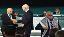 رئيس فيفا جياني إنفانتينو يصافح رئيس الاتحاد الإسرائيلي لكرة القدم موشيه زواريز، بينما يغادر رئيس الاتحاد الفلسطيني جبريل الرجوب المنصة خلال كونغرس فيفا في فانكوفر، 30 نيسان 2026. (رويترز).jpeg