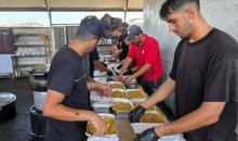 فلسطينيون ينتظرون دورهم للحصول على وجبة من مطبخ خيري في منطقة المواصي بخان يونس، جنوب قطاع غزة، في 7 أغسطس/آب 2026، وسط استمرار الأزمة الإنسانية ونقص الإمدادات الغذائية. تصوير: طارق محمد