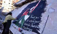 فنانون فلسطينيون يرسمون جدارية لمغني الراب الأمريكي ماكليمور على جدار مبنى دمرته الحرب في مدينة غزة، في 17 سبتمبر/أيلول 2026. تصوير: عبد الله أبو الخير
