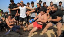 شبان فلسطينيون يمارسون تمارين وأنشطة رياضية على شاطئ النصيرات وسط قطاع غزة، يوم 16 أكتوبر/تشرين الأول 2026. (تصوير: حسن الجدي)