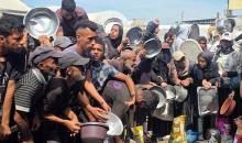 يتجمع فلسطينيون نازحون لتلقي وجبات ساخنة من مطبخ خيري، يُوصف بأنه آخر مطبخ عامل في منطقة المواصي بخان يونس، 2 أكتوبر/تشرين الأول 2026. (صورة: طارق محمد)