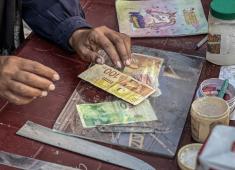 الفلسطينية منال السعيداني تُصلح أوراقًا نقدية قديمة ومهترئة في ظل نفاد العملة الصعبة في قطاع غزة (2).jpg