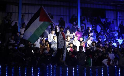 لاعبون فلسطينيون من فريقي النصيرات ورفح يتنافسون خلال مباراة كرة قدم على ملعب نادي خدمات النصيرات، ضمن بطولة غزة الرمضانية، بحضور حشد جماهيري كبير، في مخيم النصيرات بوسط قطاع غزة، بتاريخ 21 فبراير/شباط 2026. تصوير: معز صالحي / apaimages