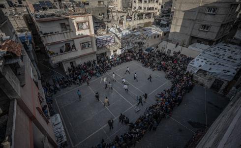 يشارك شبان وأطفال فلسطينيون في مباريات كرة الطائرة ضمن ما يُسمى دوري الحي في مخيم البريج للاجئين وسط قطاع غزة، في محاولة لإحياء الأنشطة الرياضية بعد ما يقرب من عامين من الحرب، 27 فبراير/شباط 2026. تصوير: رمزي أبو عامر