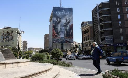 امرأة تمر أمام لوحة إعلانية كبيرة عن مضيق هرمز في طهران. (أ ف ب).jpeg