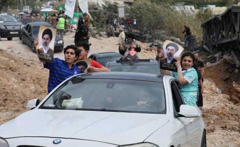 عائدون إلى الجنوب يعبرون جسر القاسمية المدمَّر بفعل غارات إسرائيلية ويحملون شعارات لـ«حزب الله» (إ.ب.أ).jpeg