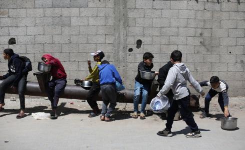 إحدى الجمعيات الخيرية توزع وجبات طعام على الفلسطينيين النازحين في مخيم النصيرات للاجئين، في ظل استمرار نقص الغذاء نتيجةً للسياسة الإسرائيلية المتعلقة بدخول المساعدات إلى قطاع غزة، في 11 أبريل/نيسان 2026. (تصوير: حسن جيدي)