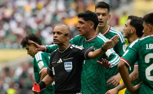 يحتج لاعبو المنتخب المكسيكي لدى الحكم البرازيلي ويلتون سامبايو بعد إشهاره البطاقة الحمراء في وجه المدافع سيزار مونتيس (أ.ب).webp