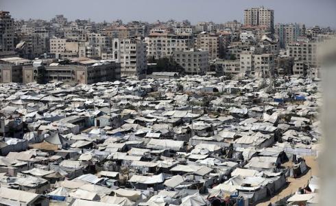 خيام تؤوي نازحين فلسطينيين على ساحل مدينة غزة وبين مبانٍ متضررة جراء الحرب، في 10 أغسطس/آب 2026. تصوير: بلال أسامة.