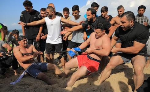 شبان فلسطينيون يمارسون تمارين وأنشطة رياضية على شاطئ النصيرات وسط قطاع غزة، يوم 16 أكتوبر/تشرين الأول 2026. (تصوير: حسن الجدي)