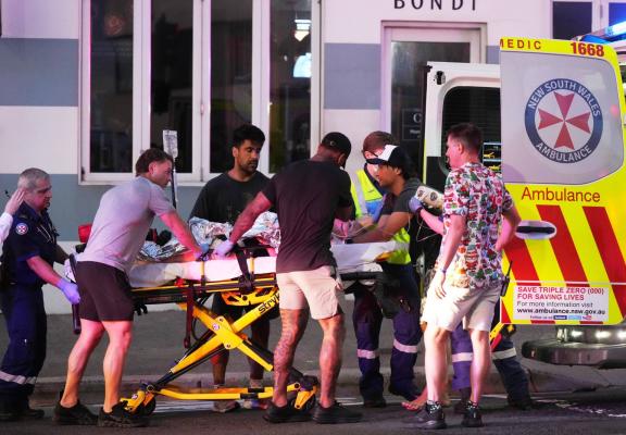 أفراد الإنقاذ ينقلون مصاباً بعد إطلاق النار في الشاطئ بسيدني (أ.ب).jpeg