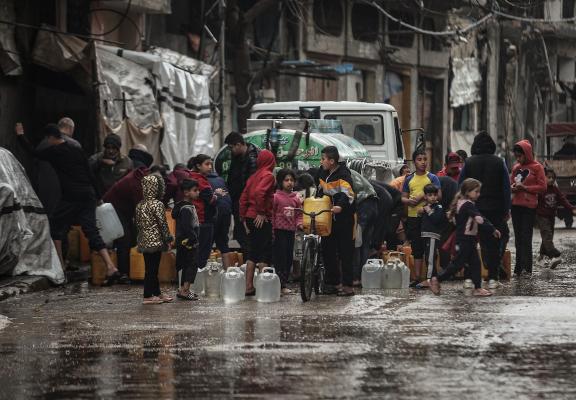 في مخيم البريج بوسط قطاع غزة، بتاريخ 26 مارس/آذار 2026، يعانى الفلسطينيون النازحون من صعوبة الحصول على مياه الشرب وسط هطول الأمطار وتفاقم الأوضاع المعيشية داخل خيامهم نتيجة عاصفة وانهيار البنية التحتية ونقص الاحتياجات الأساسية. (صورة: معز صالحي)