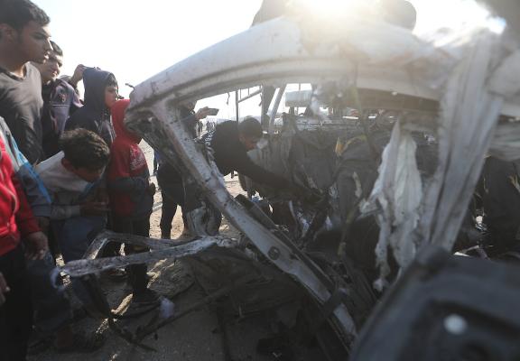 يتفقد فلسطينيون موقع هجوم إسرائيلي على سيارة شرطة قرب مدخل بلدة الزويدة وسط قطاع غزة، في 15 مارس/آذار 2026