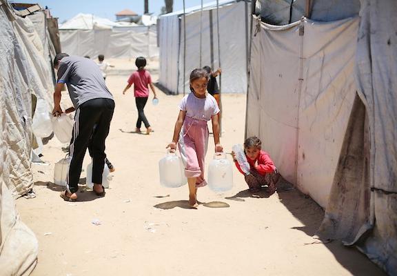 نساء وأطفال فلسطينيون يصطفون للحصول على مياه الشرب في منطقة الزوايدة بوسط قطاع غزة، في 18 يونيو/حزيران 2026. تصوير: حسن الجيدي