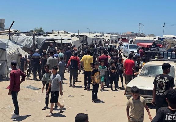 تجمّع فلسطينيون في موقع غارة إسرائيلية استهدفت دراجة نارية كهربائية قرب خيمة تأوي نازحين غرب خان يونس جنوب قطاع غزة في 2 يونيو/حزيران 2026. وبحسب مصادر طبية، أسفرت الغارة عن إصابة 10 أشخاص، بينهم اثنان في حالة حرجة. (صورة: طارق محمد)