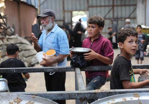 يتجمع فلسطينيون نازحون لتلقي وجبات طعام من مطبخ خيري في مخيم النصيرات للاجئين، وسط قطاع غزة، في 30 يوليو/تموز 2026. صورة: حسن الجدي