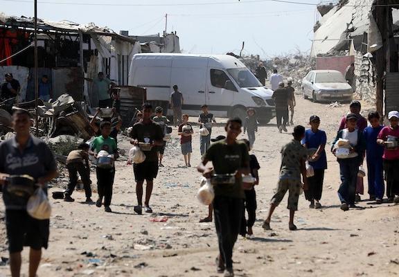في الثاني من يوليو/تموز 2026، تجمع فلسطينيون نازحون، بينهم نساء وأطفال، لتلقي وجبات طعام من مركز توزيع خيري شرق مدينة غزة.صورة: بلال أسامة