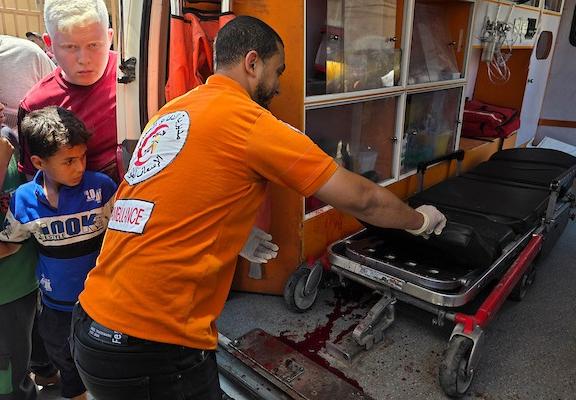 يحمل مسعفون جثتي شخصين بينما يتفقد آخرون موقع غارة إسرائيلية استهدفت تجمعًا فلسطينيًا في منطقة بطن السمين، جنوب خان يونس، 9 يوليو/تموز 2026. صورة: طارق محمد