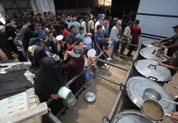 يتجمع فلسطينيون نازحون لتلقي وجبات طعام من مطبخ خيري في مخيم النصيرات للاجئين، وسط قطاع غزة، في 30 يوليو/تموز 2026. صورة: حسن الجدي