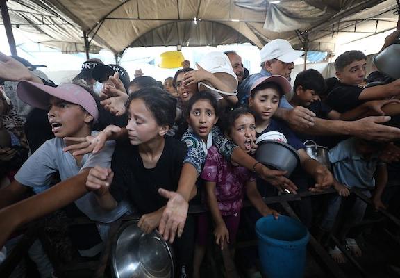 تجمع فلسطينيون نازحون لتلقي وجبات طعام من مطبخ خيري في مخيم النصيرات للاجئين، وسط قطاع غزة، في 16 أغسطس/آب 2026. صورة: حسن الجدي