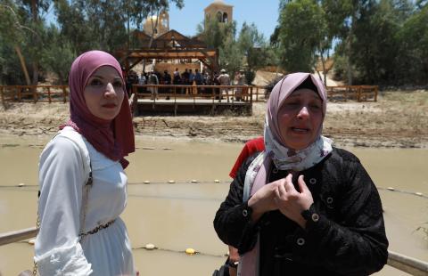  الفلسطينية سناء محمد تقف على الجهة الغربية من منطقة "المغطس" التي تسيطر عليها إسرائيل بينما عائلتها على الجهة الشرقية (بالجانب الأردني) دون أن يتمكنا من احتضان بعضهما