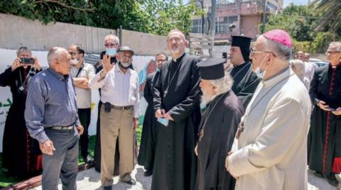 زيارة رئيس أساقفة القدس اللاتينيين بييرباتيستا بيتسابالا (وسط) لحي الشيخ جراح أمس (أ.ف.ب)