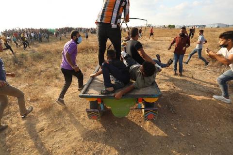 متظاهرون فلسطينيون يخلون شاب مصاب على عربة حصان شرق غزة 
