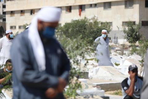    فلسطينيون يدفنون جثمان المواطنة زانة خطاب، توفت اثر اصابتها بفايروس كورونا، في دير البلح وسط قطاع غزة