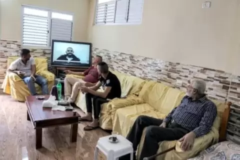 أفراد من عائلة المعتقل الفلسطيني الفار من احد السجون الاسرائيلية زكريا الزبيدي يتابعون شاشة التلفزيون مترقبين اي اخبار قد ترد عن مصير ابنهم وخمسة آخرين فروا من سجن جلبوع (شمال) في منزل العائلة في مخيم جنين في السابع من أيلول/سبتمبر 2021