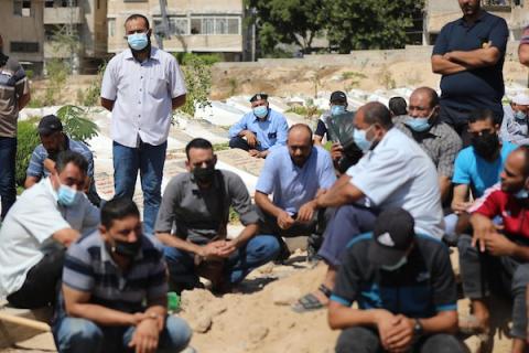     فلسطينيون يدفنون جثمان المواطنة زانة خطاب، توفت اثر اصابتها بفايروس كورونا، في دير البلح وسط قطاع غزة