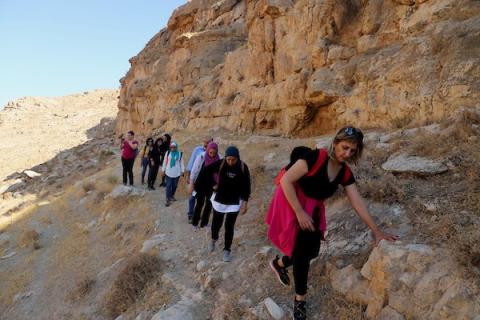    فلسطينيون يسيرون وسط المنحدرات الخطرة خلال رحلتهم لاستكشاف وادي ومغارة القديس خريطون بالقرب من بيت لحم