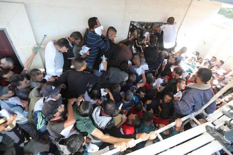 مواطنون فلسطينيون ينتظرون أمام مقر الغرفة التجارية للتسجيل من اجل العمل في إسرائيل، في دير البلح وسط قطاع غزة(25)
