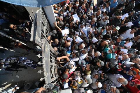مواطنون فلسطينيون ينتظرون أمام مقر الغرفة التجارية للتسجيل من اجل العمل في إسرائيل، في دير البلح وسط قطاع غزة(17)