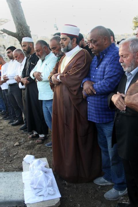    فلسطينيون يؤدون الصلاة على بقايا الرفات من القبور التي هدمتها قوات الاحتلال الإسرائيلي في المقبرة اليوسفية في القدس، قبل إعادة دفنها مرة أخرى