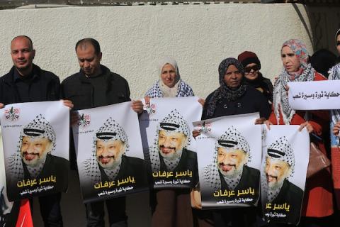 فلسطينيون يشاركون في مسيرة ضد عرض الرسوم الكاريكاتورية للرئيس الراحل ياسر عرفات في معرض أمام منزله بمدينة غزة