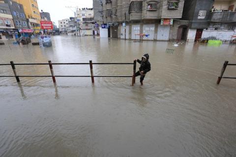 الدفاع المدني الفلسطيني ينتشل سكان من شارع غمرته مياه الأمطار ، في مخيم جباليا للاجئين الفلسطينيين شمال قطاع غزة 