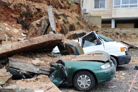    فلسطينيون يتفقدون مركباتهم المدمرة جراء سقوط جدار عليها بفعل المنخفض الجوي في مدينة رام الله(15)