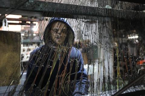 عمال فلسطينيون يعملون في مصنع للحصائر في جباليا