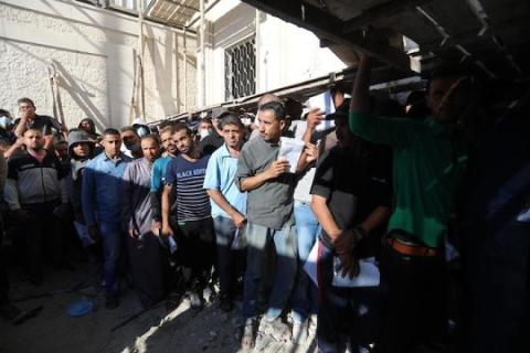 مواطنون فلسطينيون ينتظرون أمام مقر الغرفة التجارية للتسجيل من اجل العمل في إسرائيل، في دير البلح وسط قطاع غزة.jpg